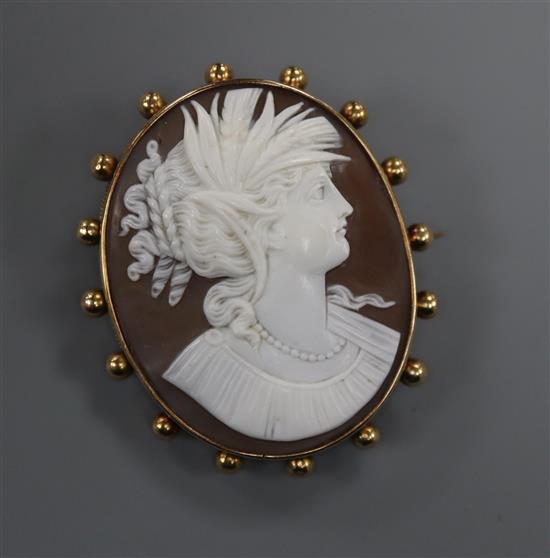 A yellow metal mounted oval cameo brooch, carved with the bust of a lady to sinister, 49mm.